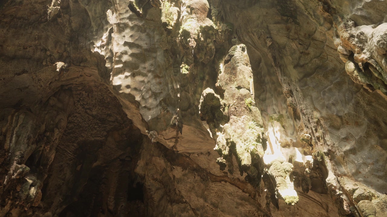 Interno suggestivo delle Grotte di Batu che mostra imponenti formazioni rocciose modellate dall'erosione e dal flusso costante dell'acqua