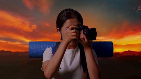 mujer tomando una foto de una hermosa puesta de sol sobre las montañas