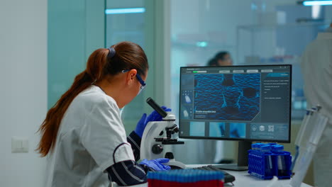 científico de biotecnología que investiga en el laboratorio utilizando el microscopio