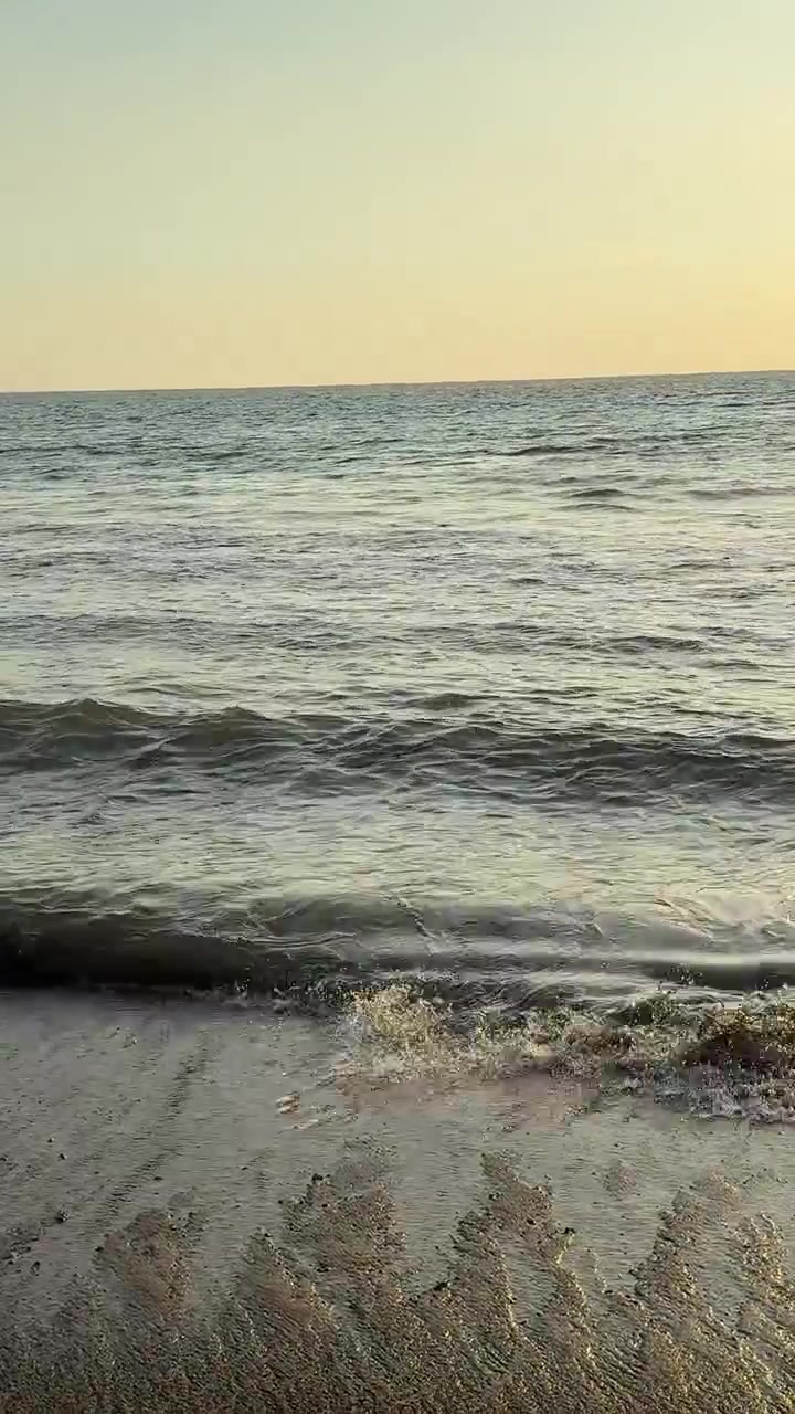 Onde serene dell'oceano che lambiscono dolcemente una spiaggia sabbiosa