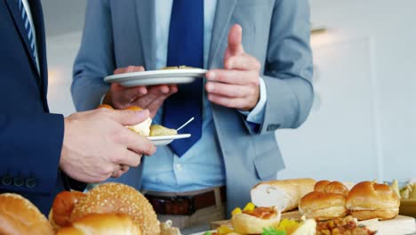 dos hombres hablando juntos con un plato en la mano