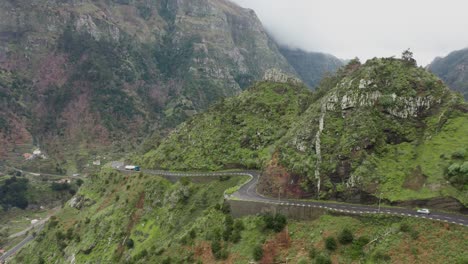 scenic epic winding road on mountain ridge in madeira, traffic passing by, aerial