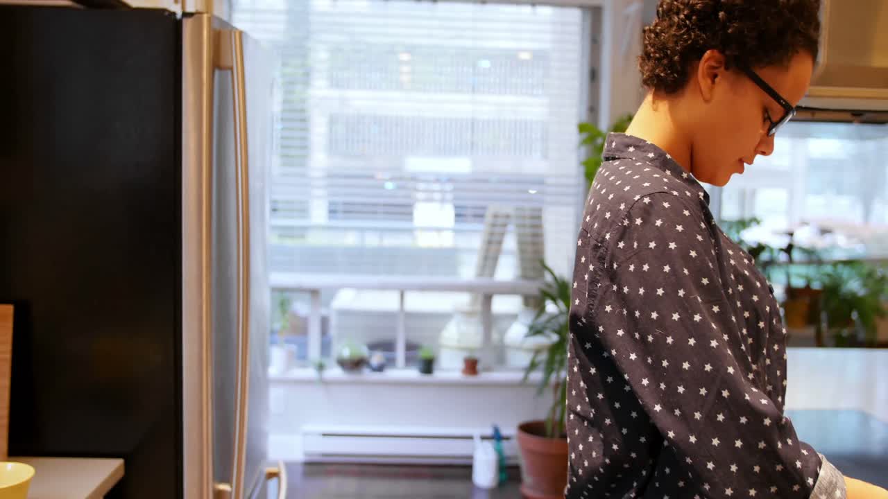 mujer quitando la lata de comida del refrigerador 4k