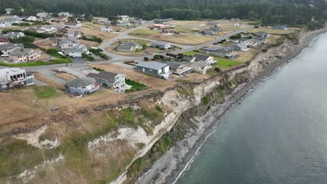 drone shot of houses perched on the edge of an eroding bluff on whidbey island