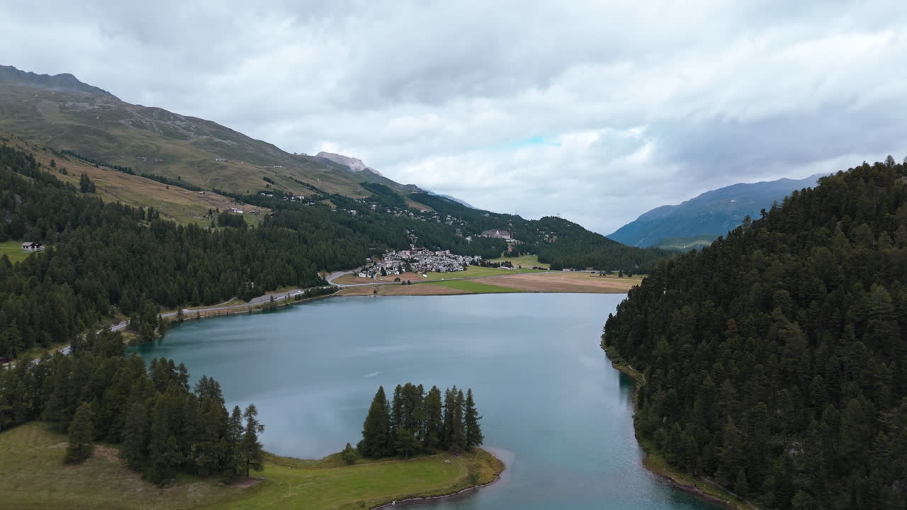 Tranquil lake near Silvaplana with mountains and forest in serene setting