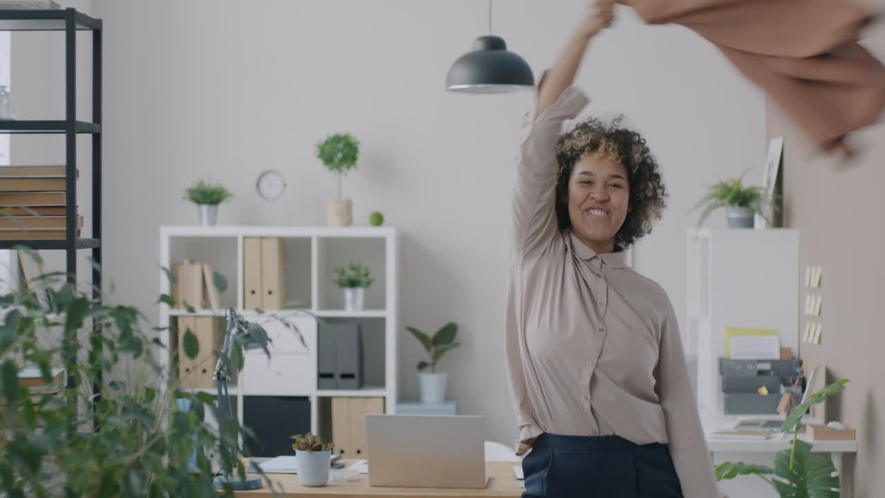 Happy Woman Throwing a Shirt in a Modern Office