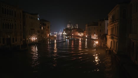 venetian grand canal with santa maria della salute by night, luminous reflections, italy