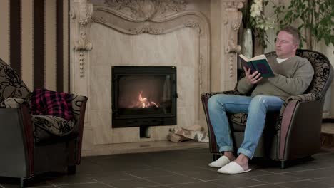 man reading by the fireplace