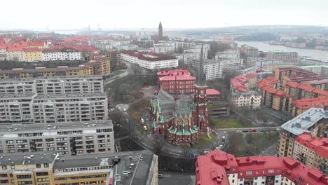 stunning zoom out aerial view of downtown oscar fredrik church surrounded by skyline and buildings on a cloudy and rainy winter day in gothenburg city, sweden