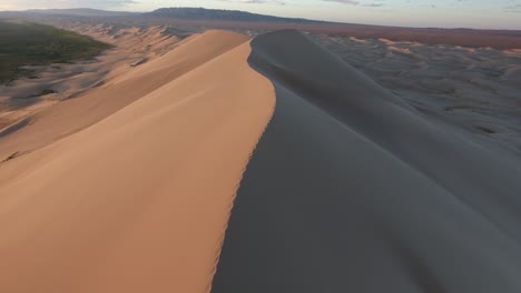 aerial drone shot in gobi desert following the edge of a sand dune in mongolia