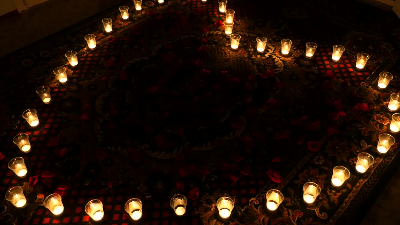 Fiery heart. Candles arranged in a heart shape. Animation of background with glowing candles in a heart shape for movie about Valentine Day or movie about Wedding Day. Animation of seamless loop