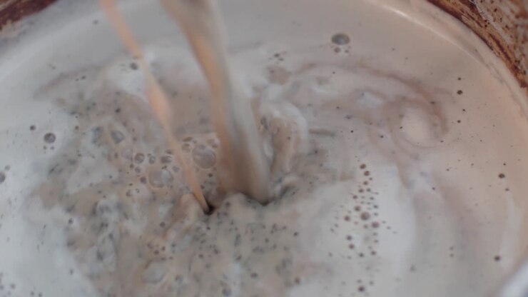 Primo piano di tè Chai indiano speziato in preparazione, bevanda tradizionale.
