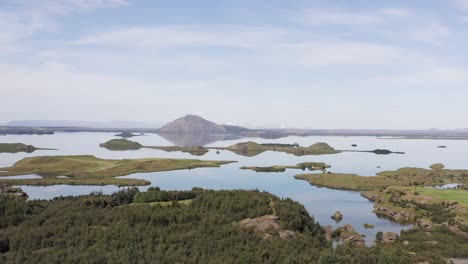 aerial of stunning myvatn lake with calm water and volcano in background