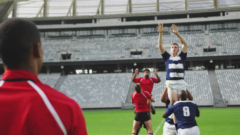 Animation-of-black-shapes-over-male-rugby-players-at-stadium