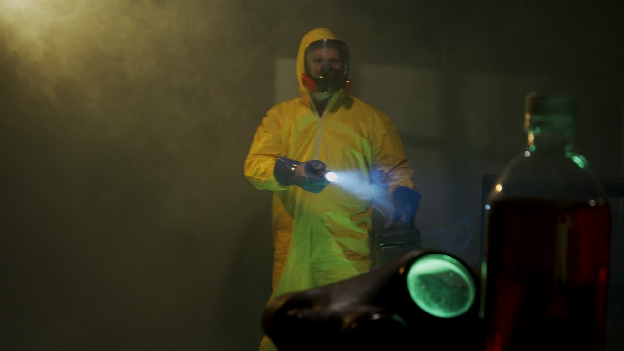 hombre vestido con traje hazmat explora una habitación oscura
