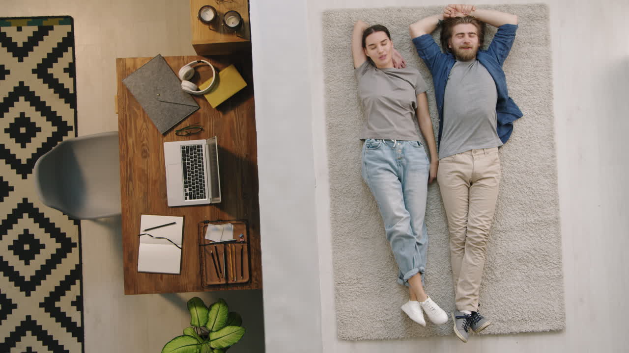 Couple Relaxing on Rug Next to Home Office