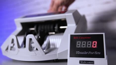 person putting money at the banking modern counter. special machine for counting banknotes. money and business concept. cropped view