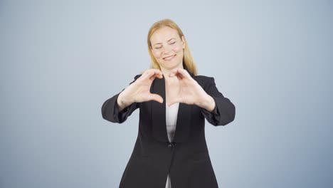 business woman making heart at camera.