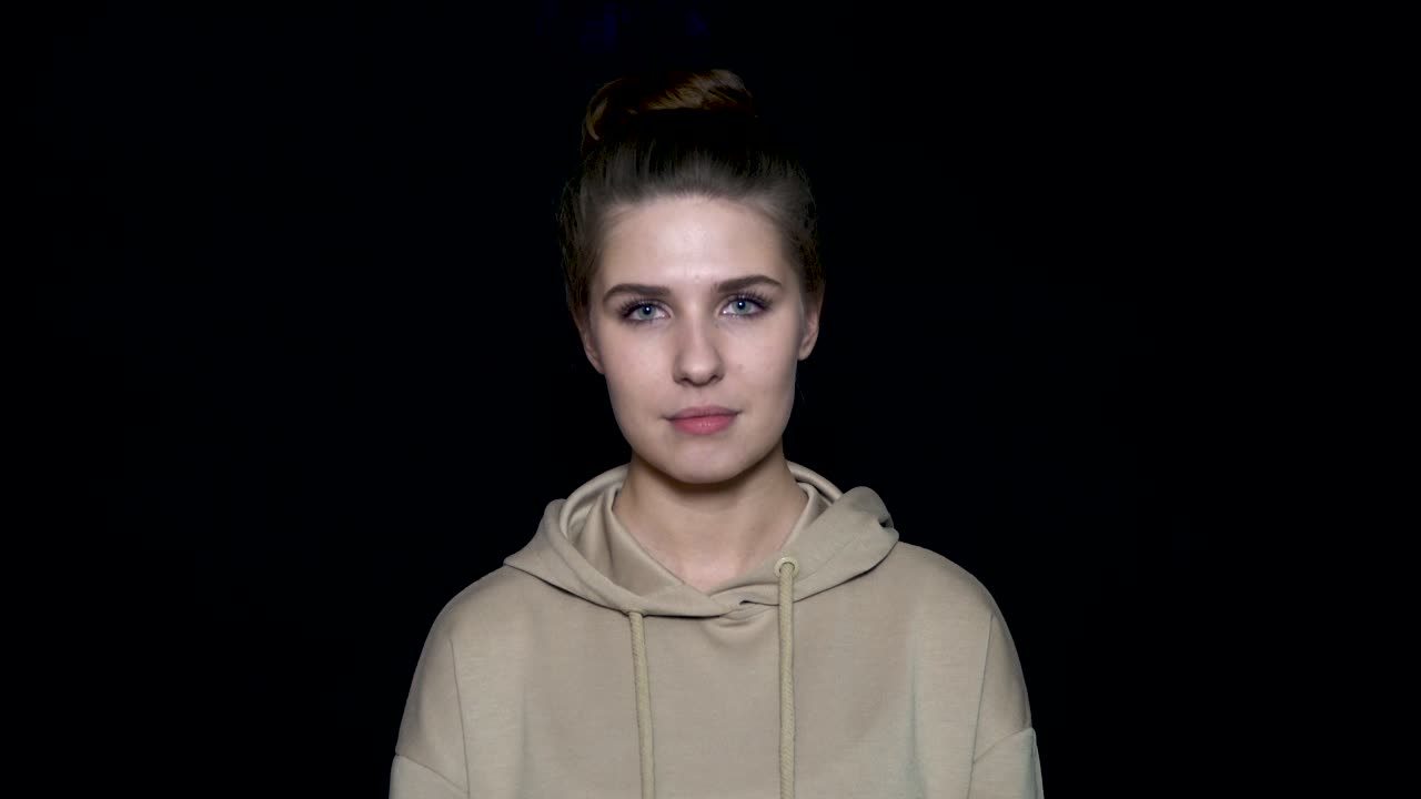 후디를 입고 미소 짓는 젊은 여성