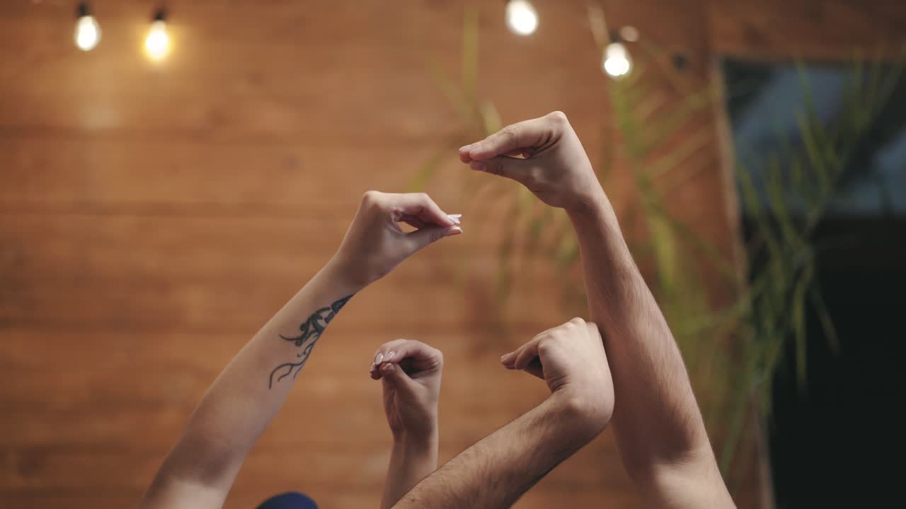 Man's hands and two female's hands making gestures trying to catch each other. Arms of loving couple playing together on romantic background. Love concept