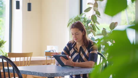 mujer usando una tableta en un café