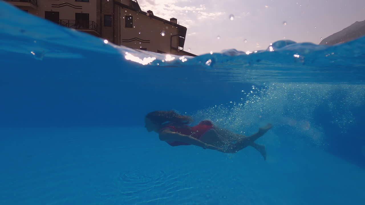 Ragazza che si tuffa sott'acqua in una piscina