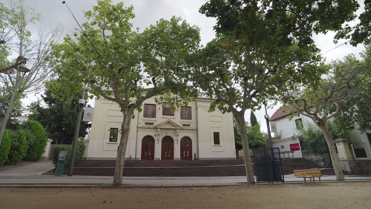 Vista panorámica del teatro histórico de La Garriga, rodeado de árboles frondosos