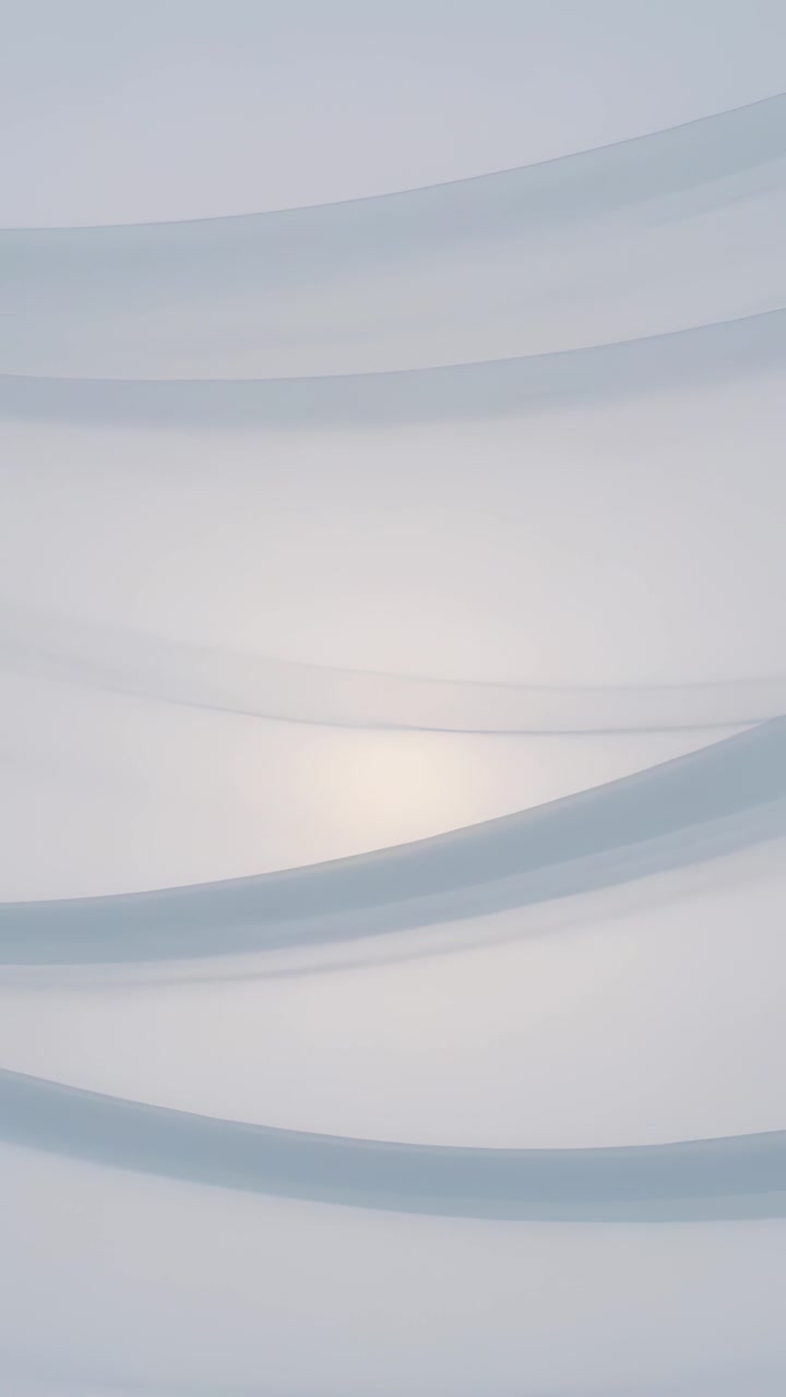 Vertical video: Opening sheer bands drifting in pale blue-gray studio backdrop, soft warm glow