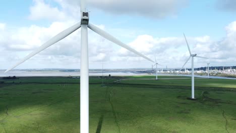 Alternative-green-energy-wind-farm-turbines-spinning-in-Frodsham-Cheshire-fields-aerial-view-slow-right-pan