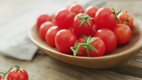 video de tomates cerezos frescos en un cuenco sobre un fondo de madera