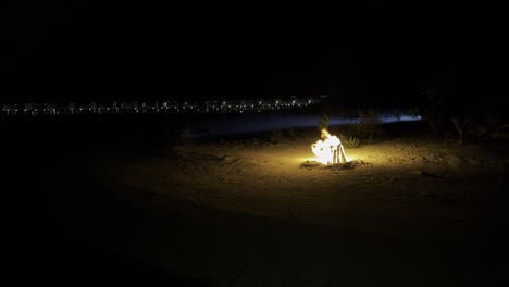 experimente el encanto de la noche de las maldivas: sienta el calor de una fascinante hoguera en la playa mientras proyecta un resplandor fascinante sobre las majestuosas olas del océano y sobre los bungalows acuáticos