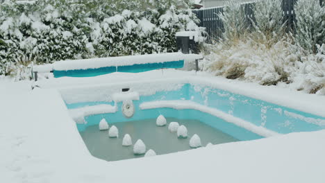 a swimming pool preserved for the winter is covered with snow.