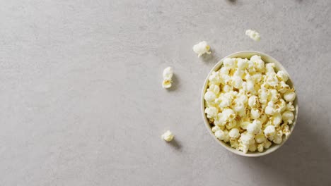 Video-of-close-up-of-box-of-popcorn-on-gray-background