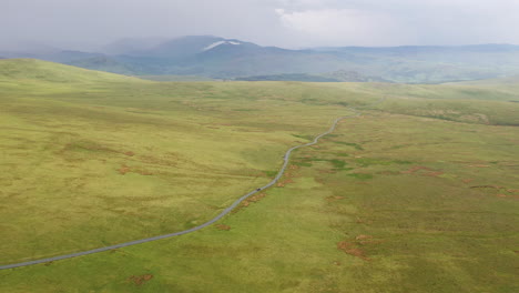 Aerial-view-of-the-natural-countryside-with-a-road-running-through,-located-in-the-English-Lake-District