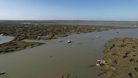 Yate-Navegando-Por-El-Río-Blackwater-Con-Marismas-En-El-Puerto-Deportivo-De-Tollesbury,-Essex,-Reino-Unido