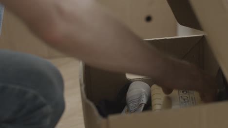 persona que está desempaquetando una caja de cartón