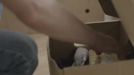 person unpacking a cardboard box