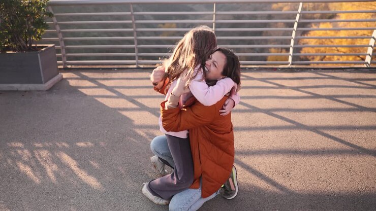 Mother and Daughter Sharing a Heartfelt Hug on a Bridge