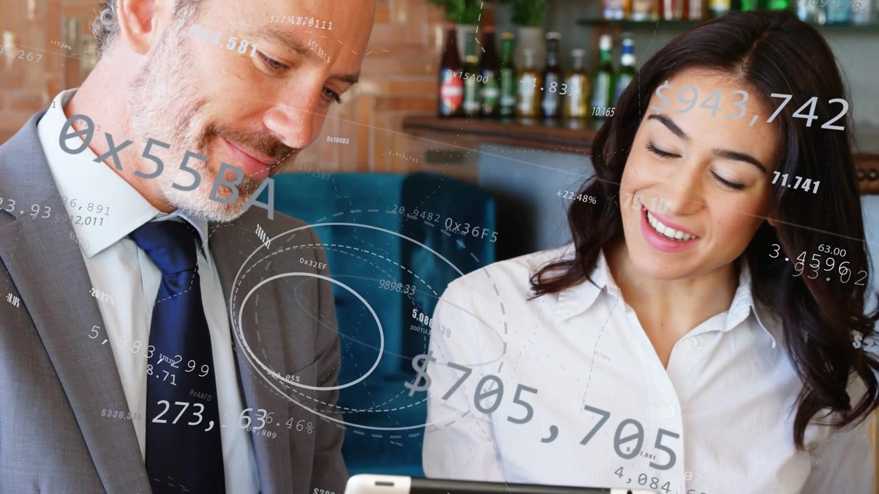 Hombre y mujer revisando una tableta en un café, con números y dólares apareciendo en pantalla, analizando sus finanzas.