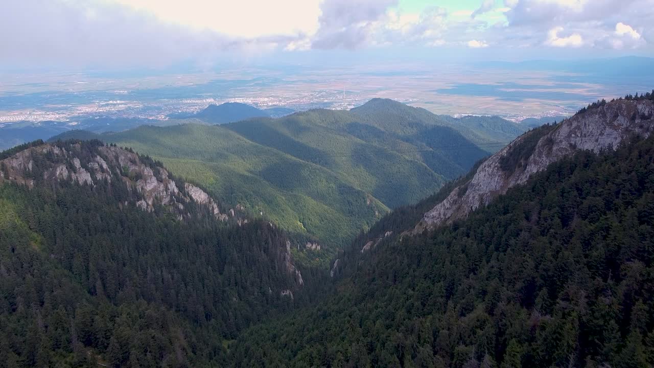 una impresionante vista aérea de un exuberante bosque montañoso envuelto en espesas nubes blancas, ubicado en poiana brasov, rumania