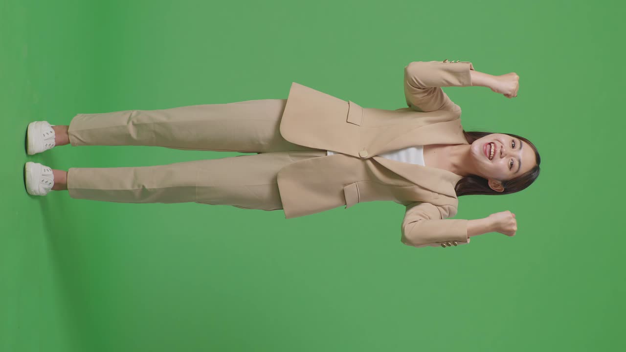 행복한 아시아 사업가 여성의 몸이 스튜디오에서 녹색 스크린에 서서 축하