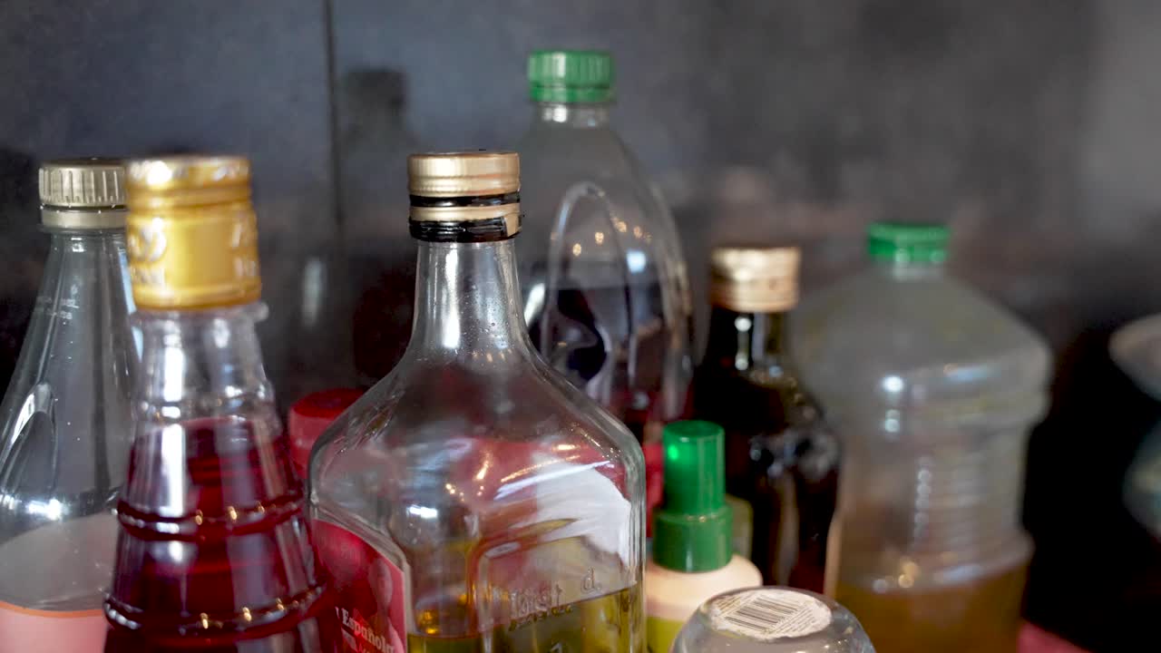 Un surtido de botellas de vidrio con varios líquidos y tapas de colores, ideales para guardar ingredientes de cocina y aceite de cocina