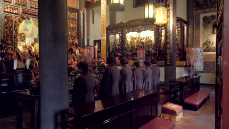 Slow motion shot of six women praying at Dalongdong Baoan Temple in Taipei, Taiwan
