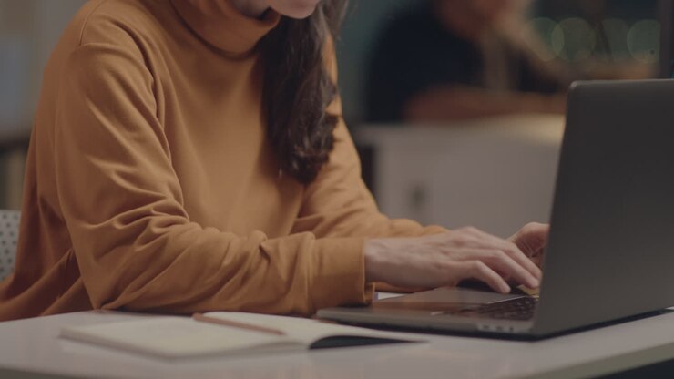 Pige arbejder på bærbar computer på kontor om natten