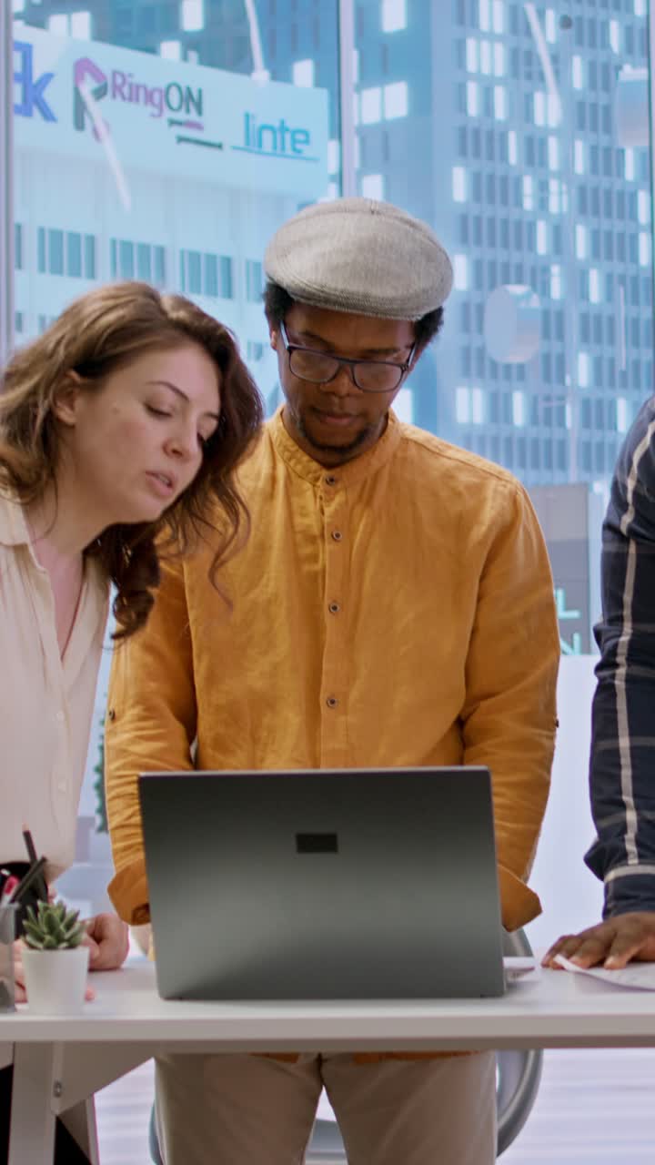 Diverse Business Team Collaborating on Laptop in Modern Office