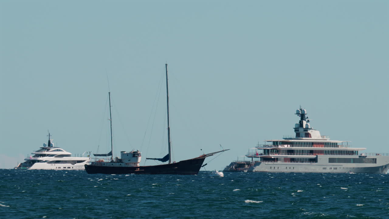 Multiple luxury yachts anchored on the blue Mediterranean Sea near the French Riviera coast