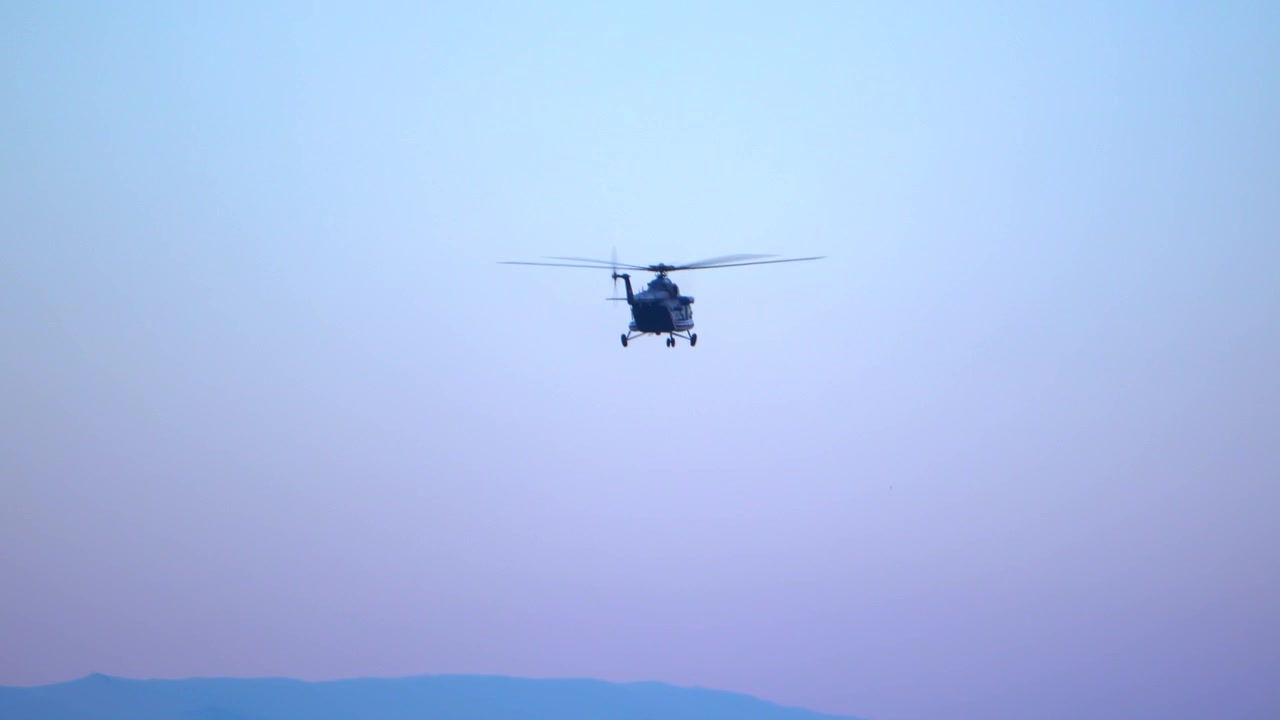A black helicopter in flight, above Sofia, descending in preparation to land on the airport