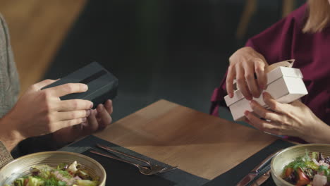 una pareja intercambiando regalos en un restaurante.