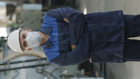 vertical portrait of factory worker in uniform and face mask