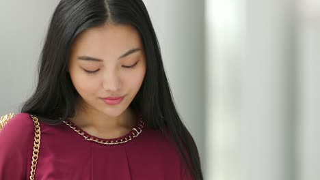 Close-up-of-Asian-woman-face-who-is-texting-then-looks-up-and-then-continues-to-text